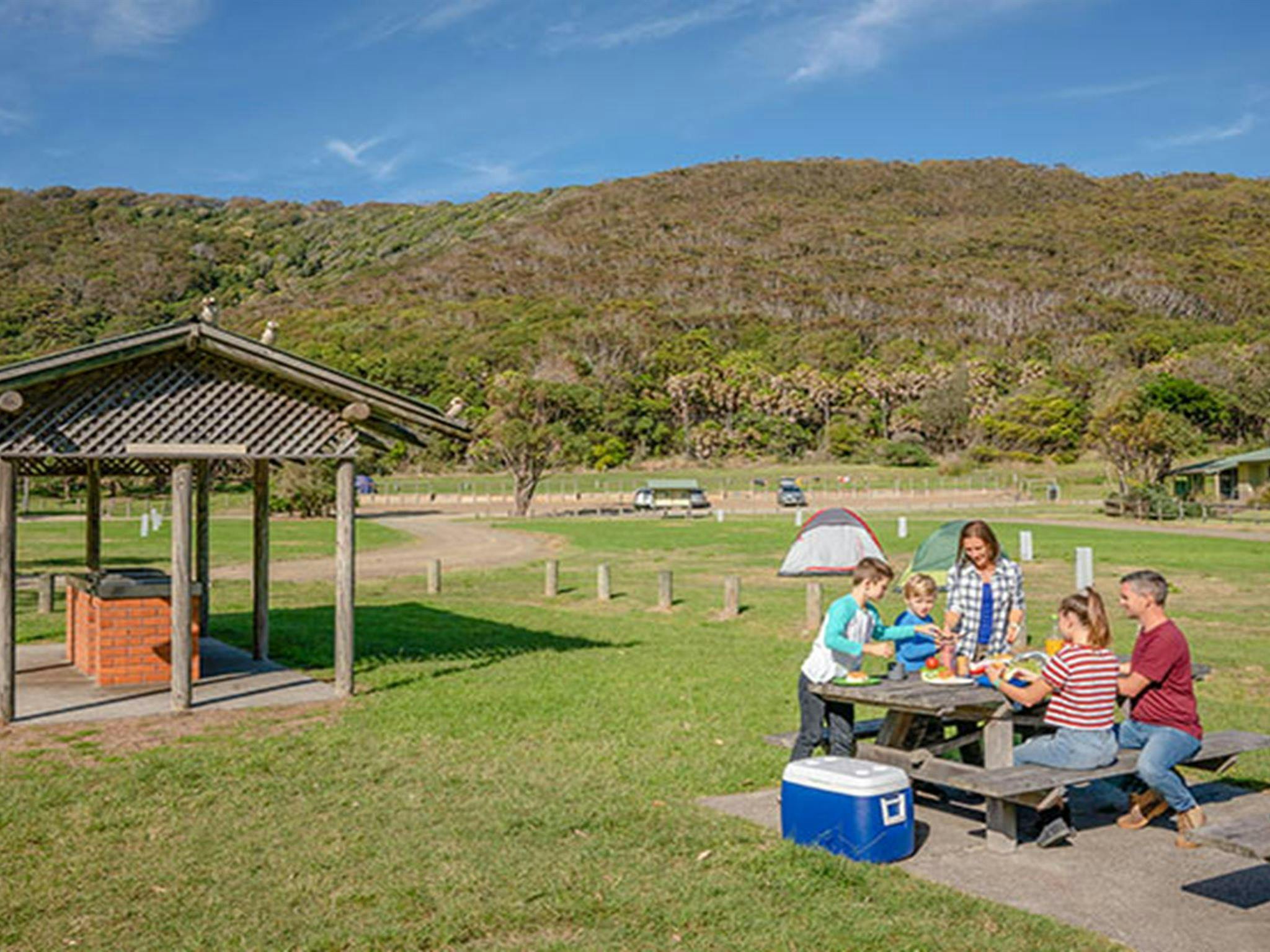 A family at a picnic table at The Ruins picnic area, Booti Booti National Park. Photo credit: John