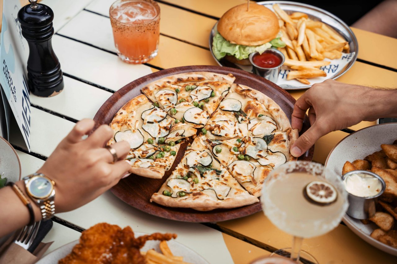 Hands picking up pizza slises