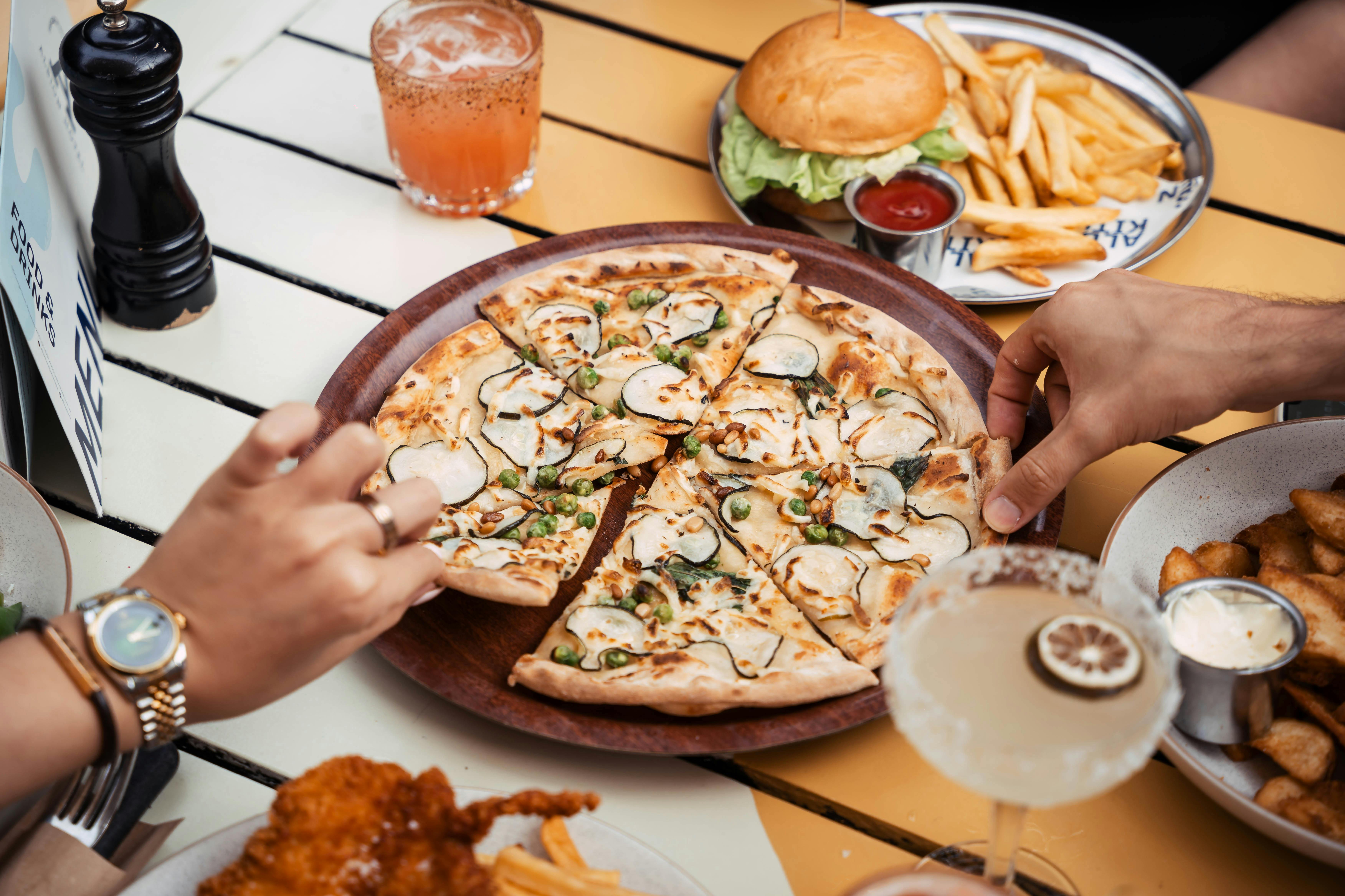 Hands picking up pizza slises