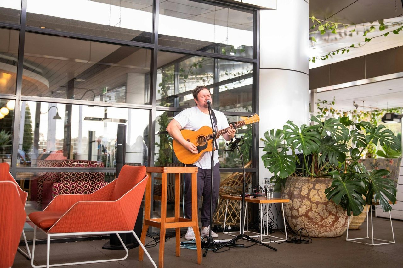 Live musician performing playing guitar at The Macarthur Tavern