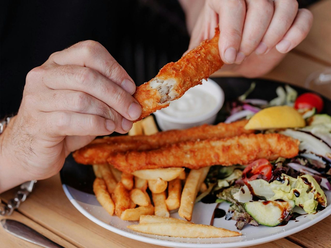 Battered flathead fish with crispy chips and a fresh salad.