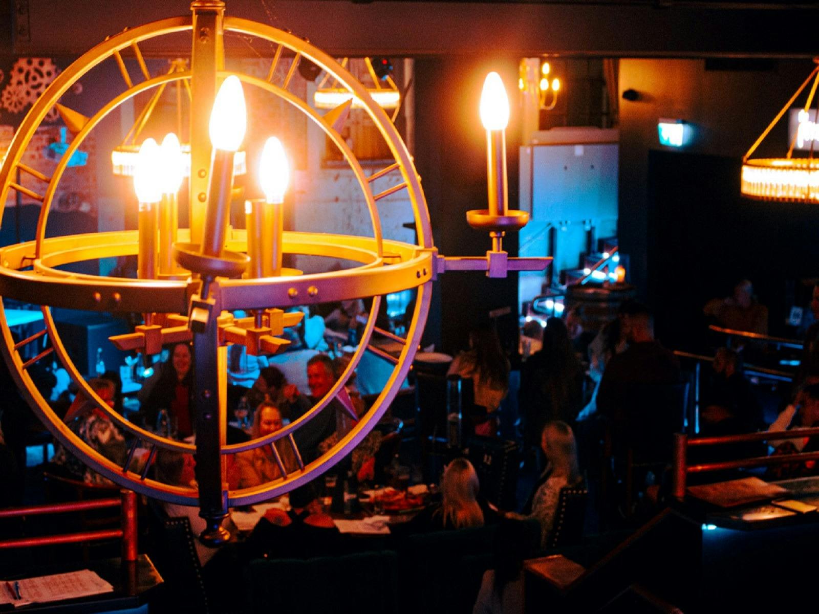 The unique candle stick chandelier hanging from the ceiling above the dining  area