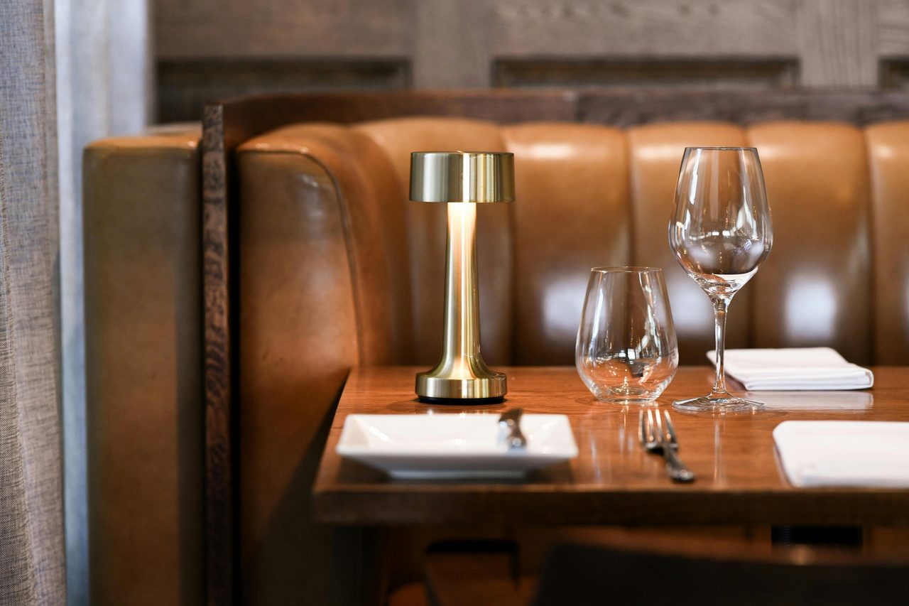 Stylish booth with soft lighting and elegant glassware ready for fine dining.