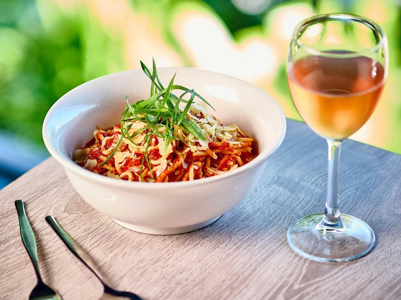 Bowl of spaghetti bolognaise with a glass of rose