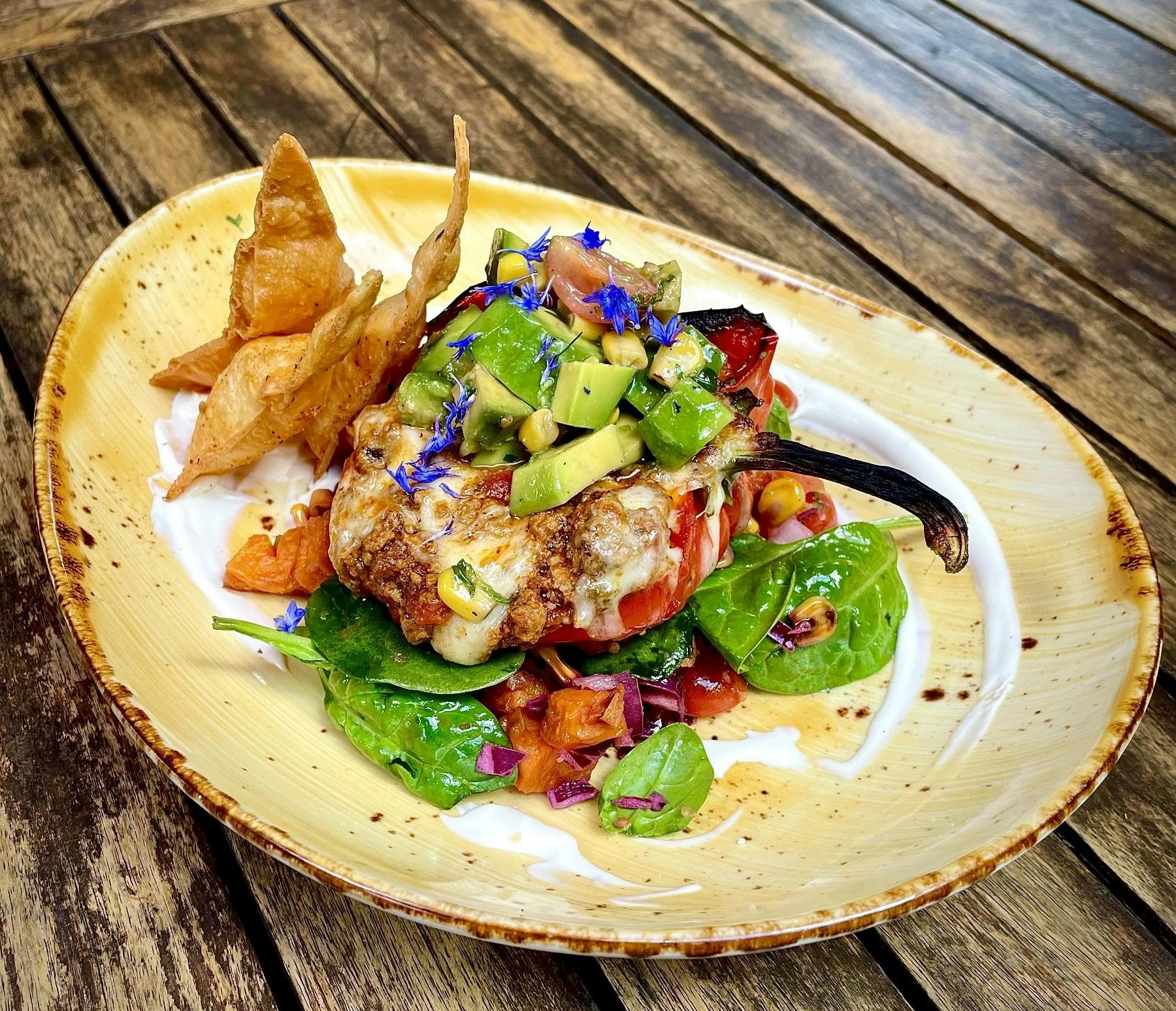 Mexican pork stuffed red pepper w/ avocado salsa, sour cream, spiced tortilla chips & sweet potato