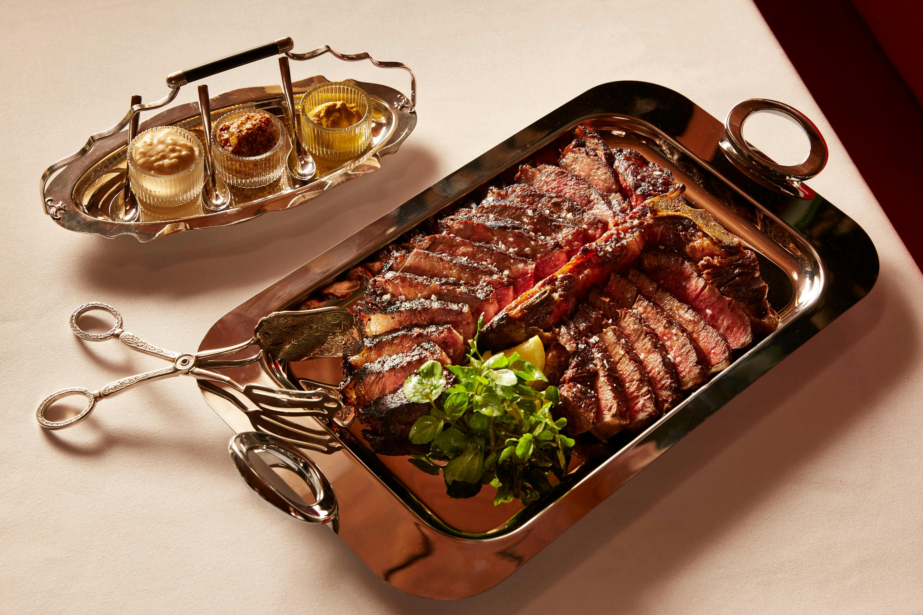 Steak on the bone on a silver tray