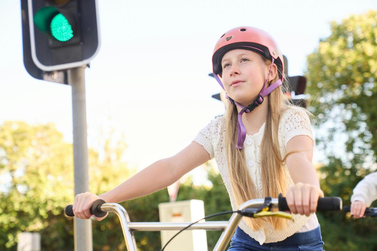 Girl riding bike in front of traffic lights