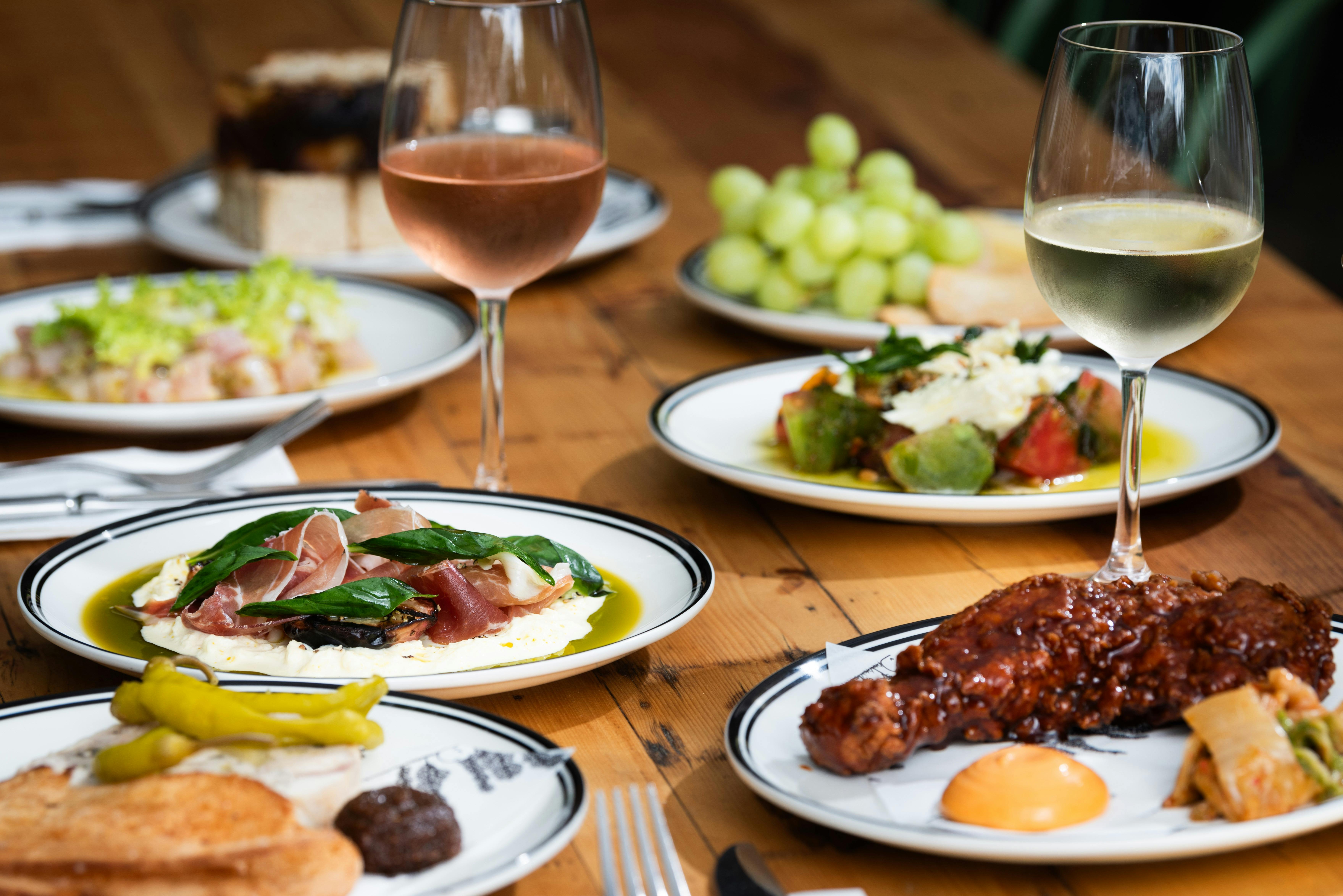 Table of delicious foods with glasses of rosé and white wine.
