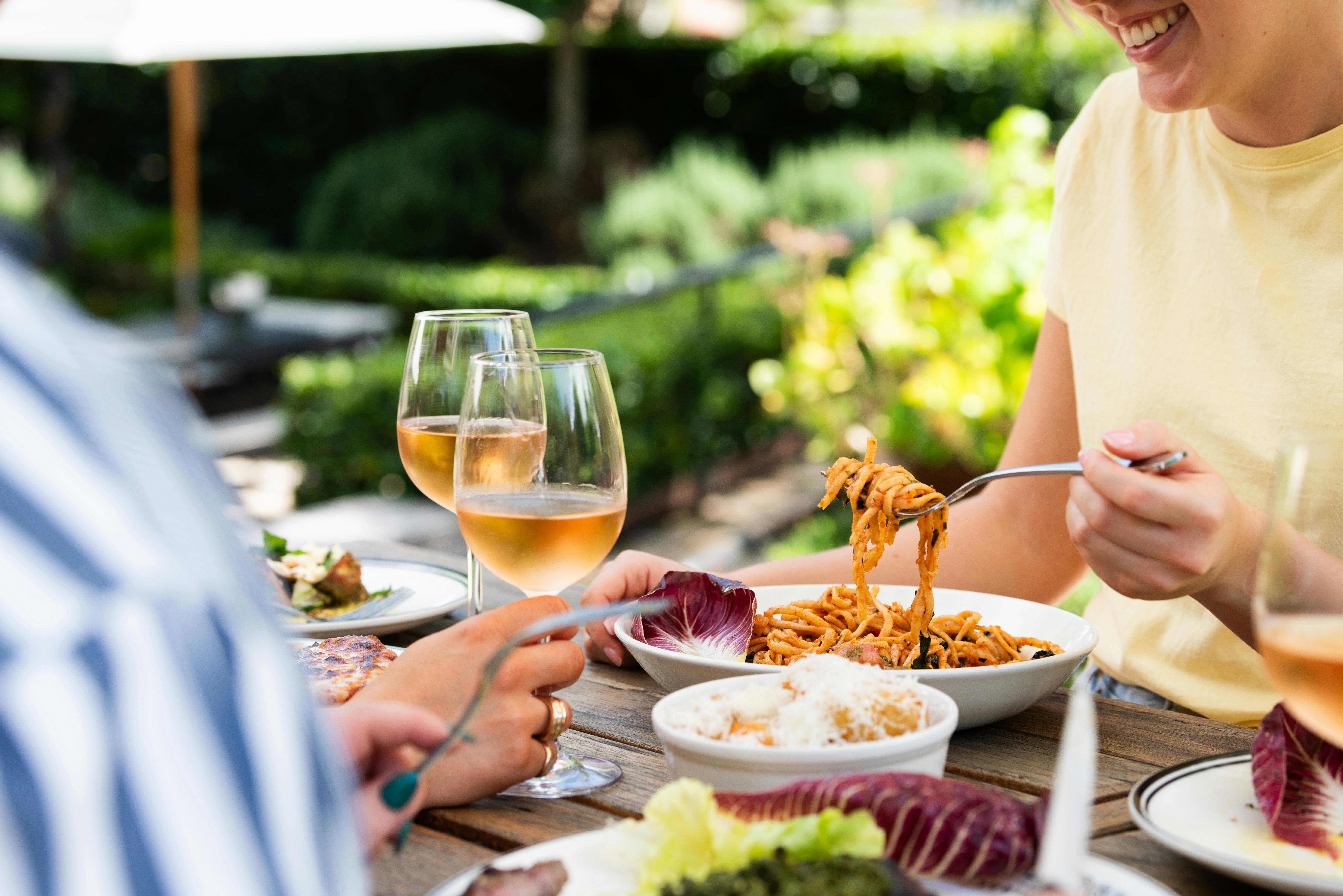 Table of food and wine set out before three guests.