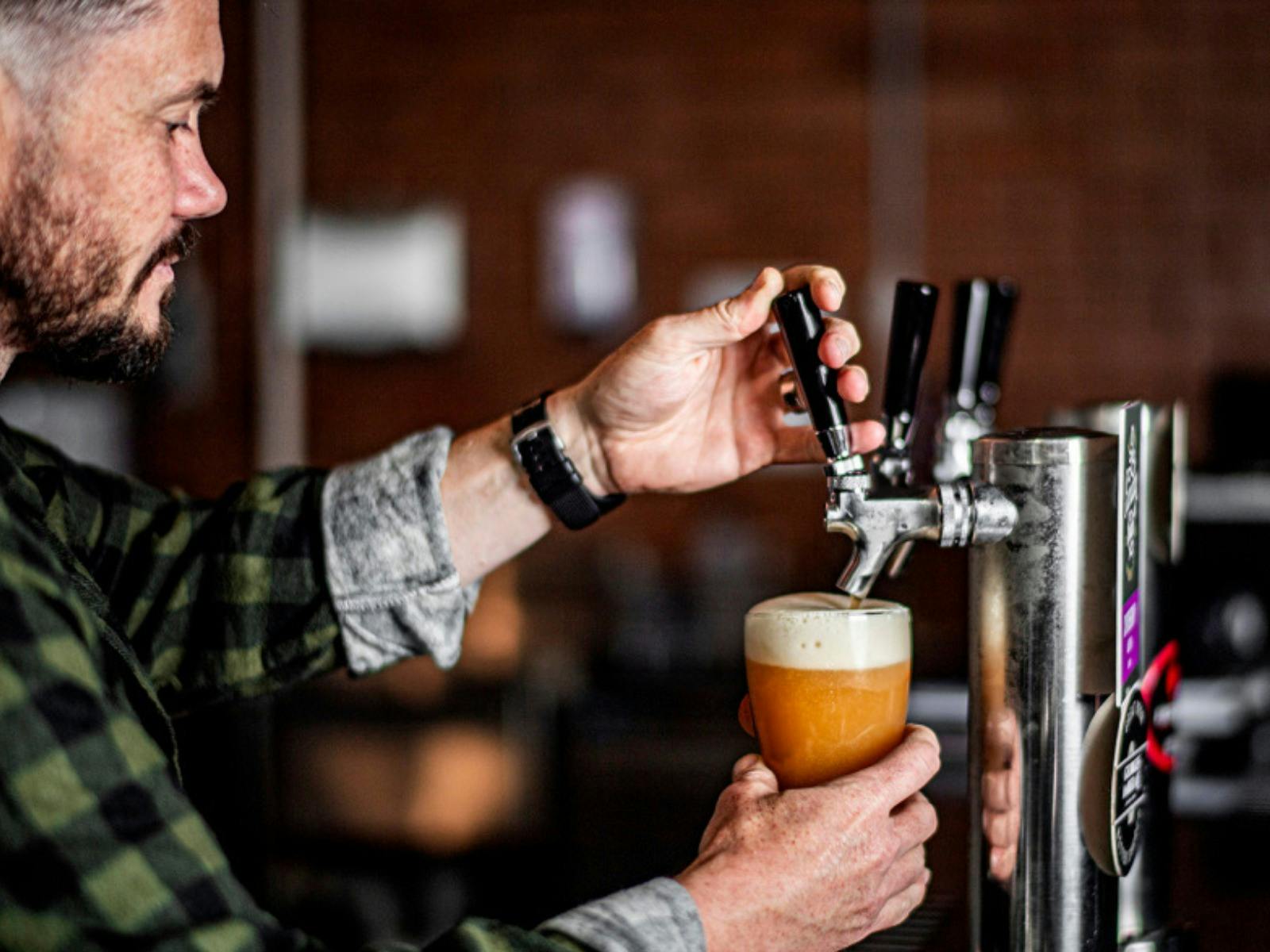 Beau pouring a beer at the social Brewers