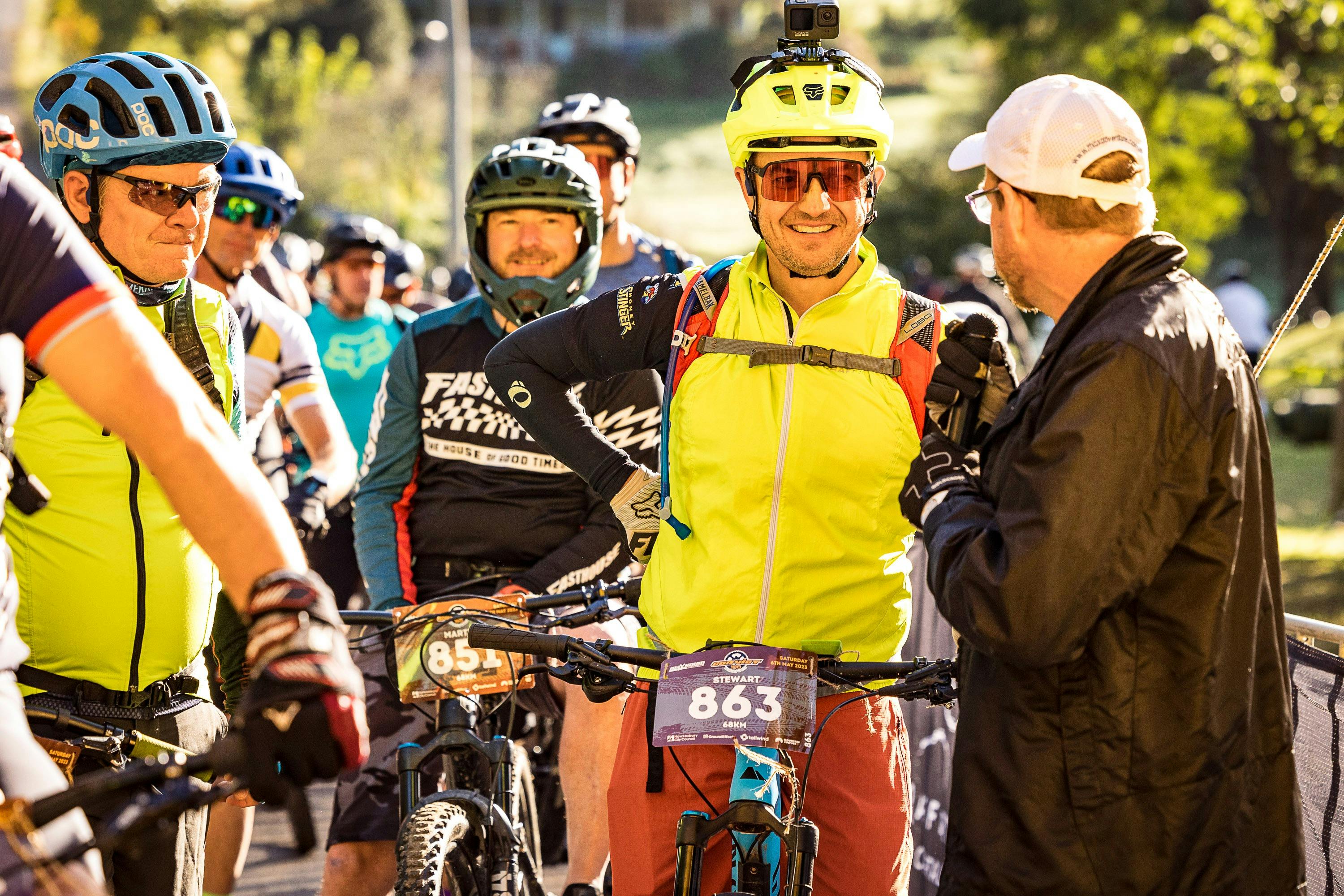 Convict 100 Race MC conducts starting-line interviews with smiling riders.