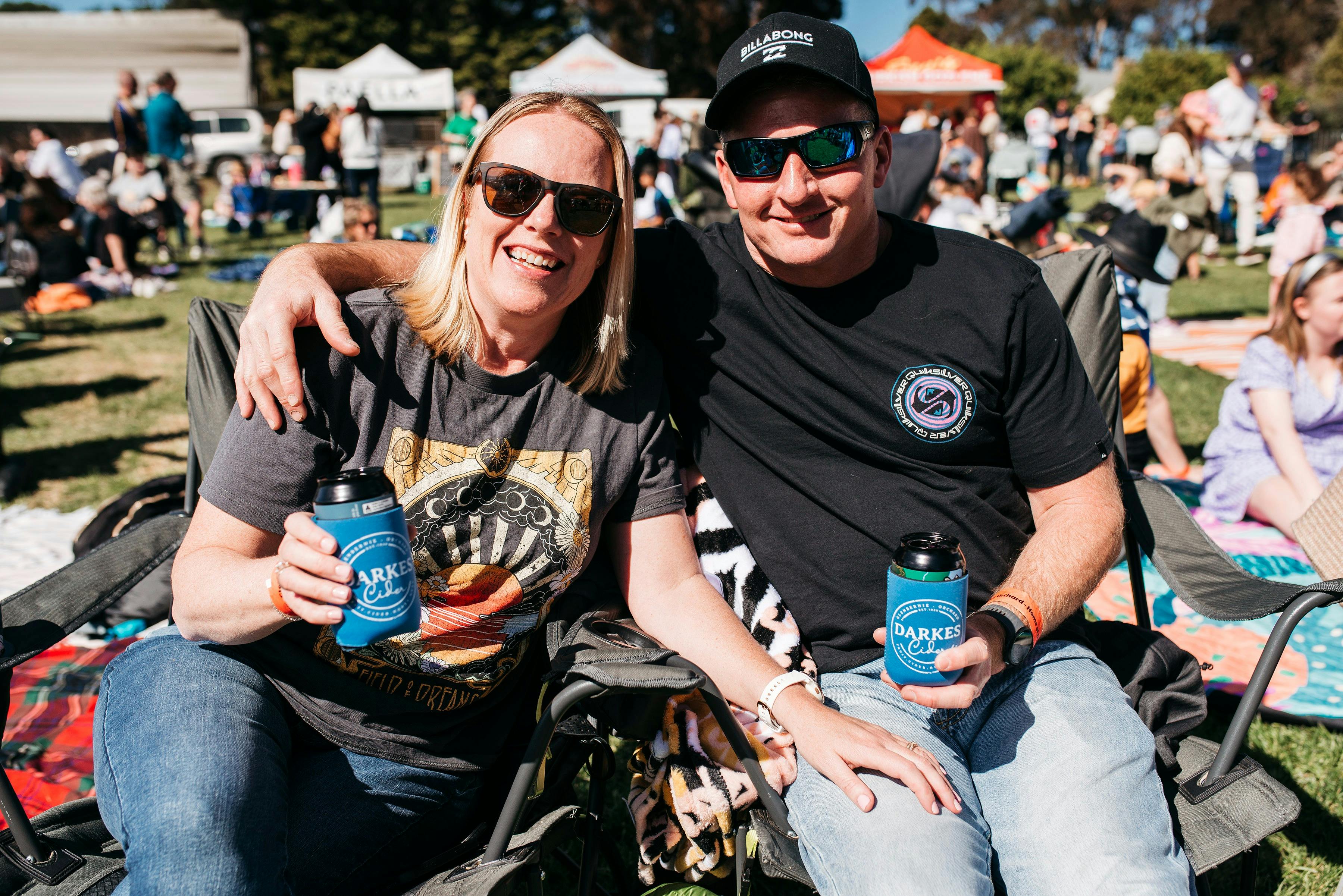 girl and guy enjoying a cider stuby sitting on the ground