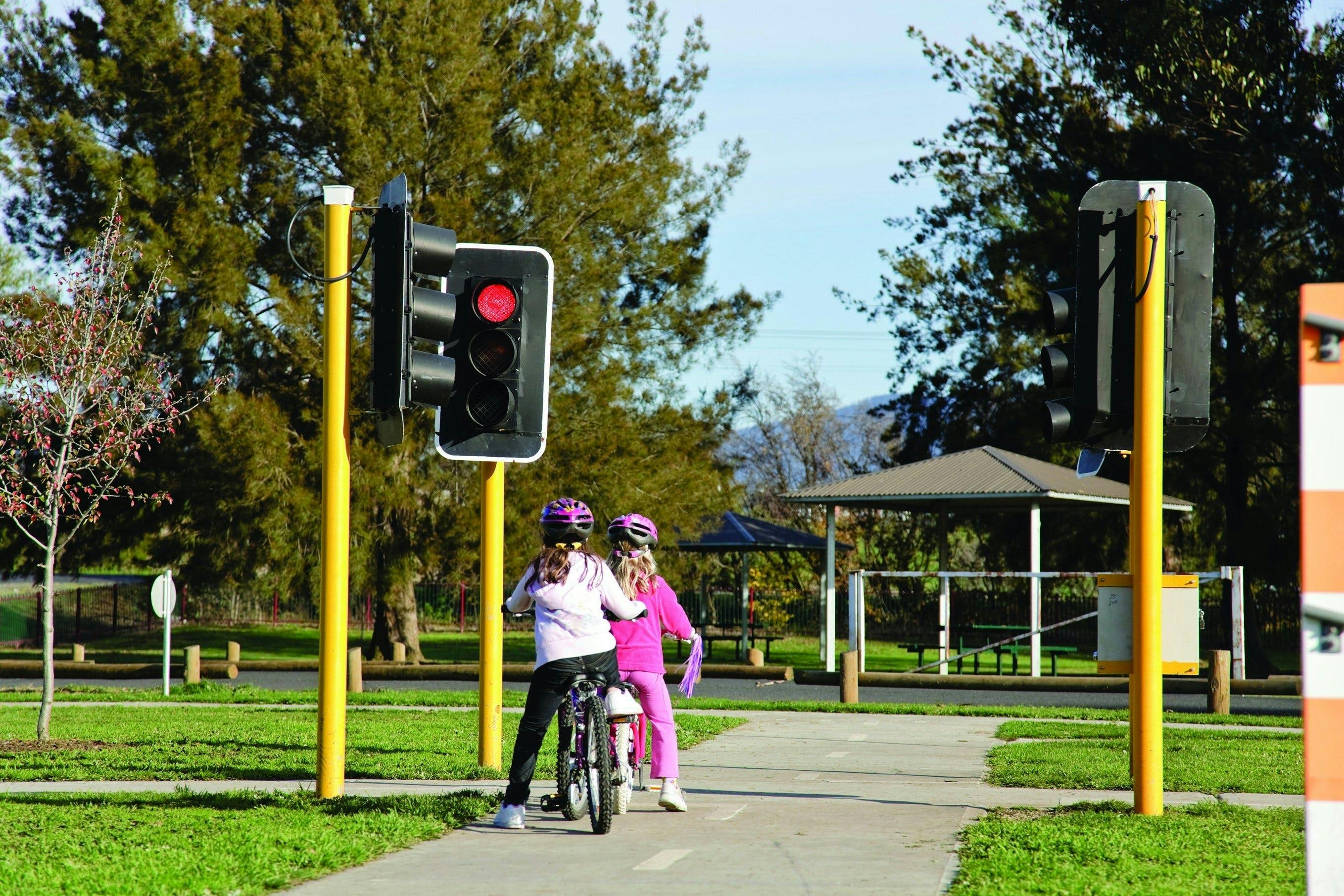 Girls riding bikes stopped at a red light