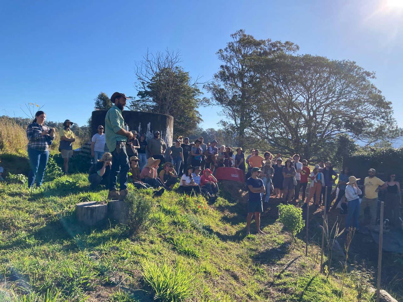 Talking to a crowd atop a hill that is cultivated