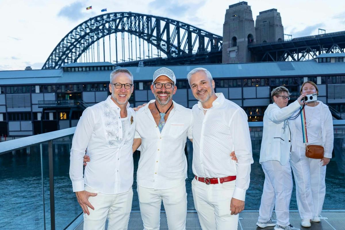 Guests arriving in white with Sydney Harbour Bridge behind them.