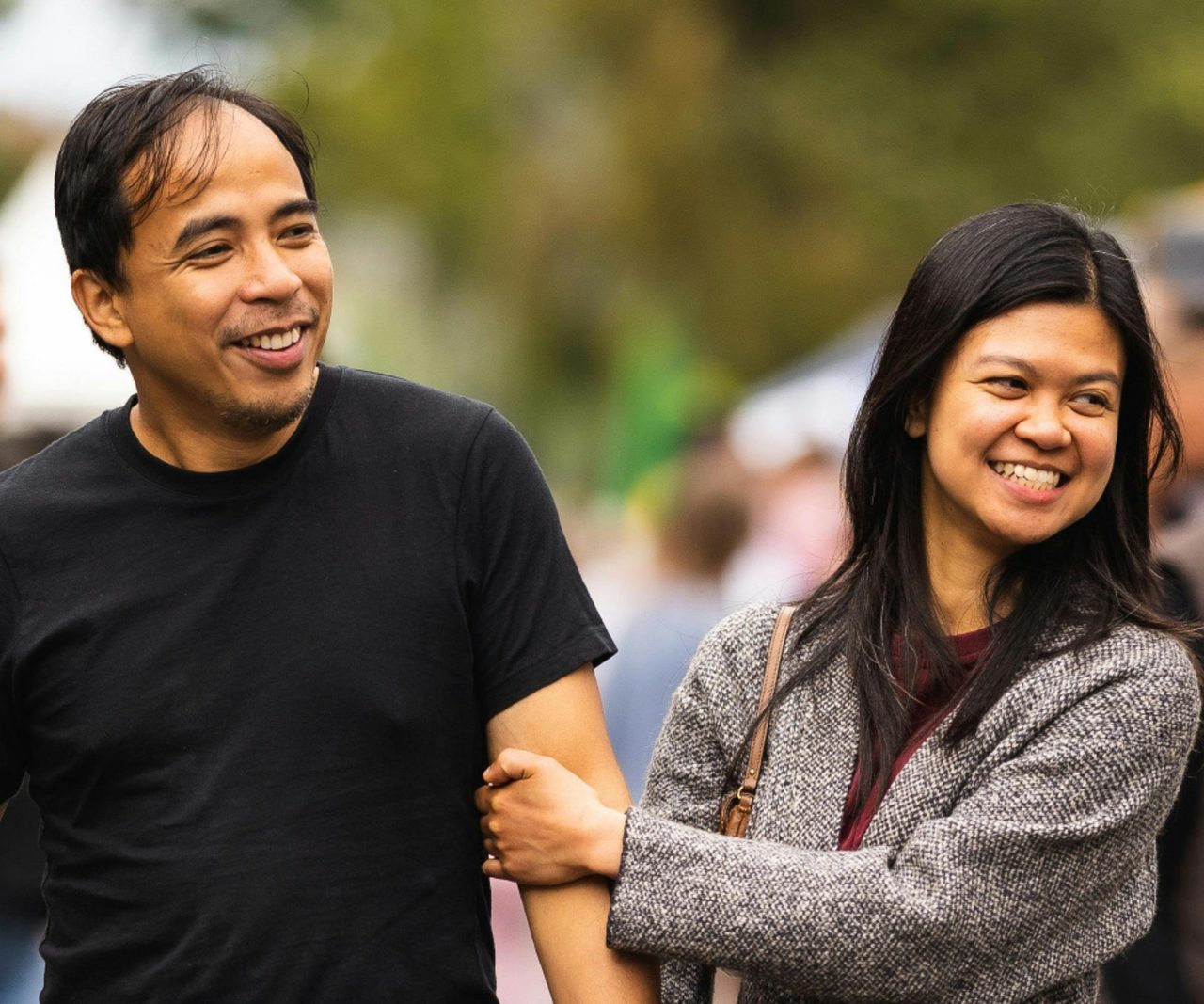 A couple are walking through the market smiling