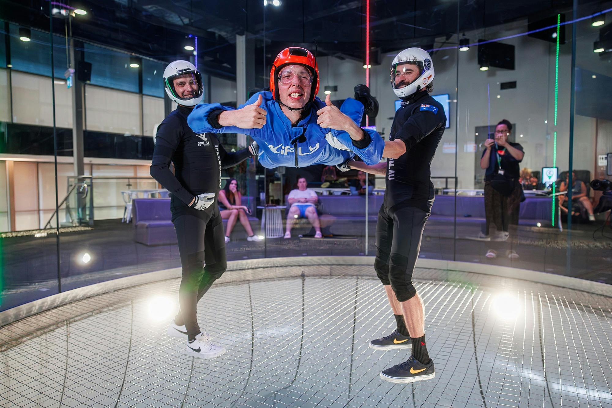 Flyer accompanied by two instructors gives a thumbs up to the camera.