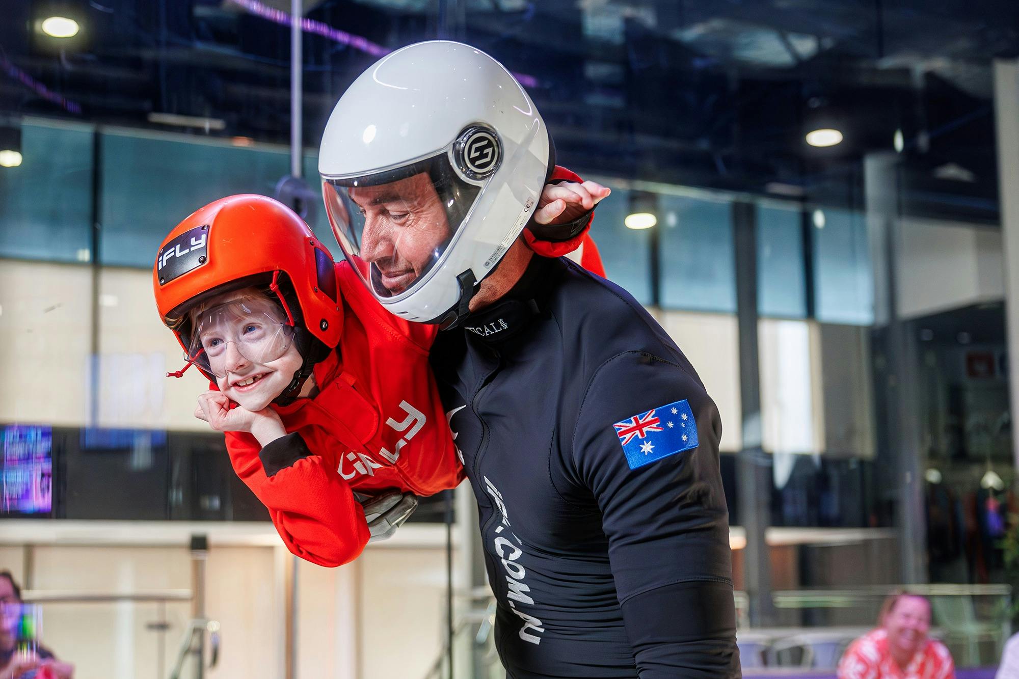 Young kid flies cautiously but happy while instructor is close by.