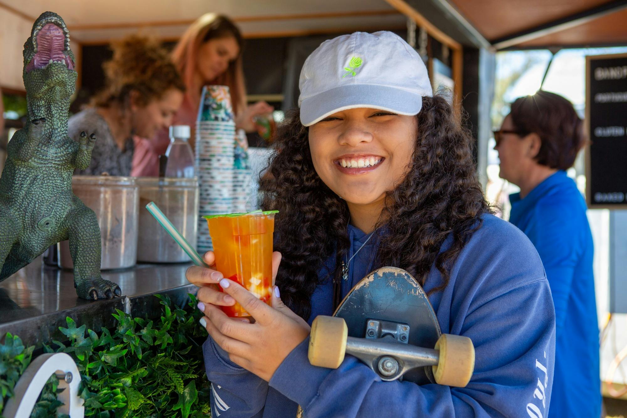 Young girl with drink at market stall