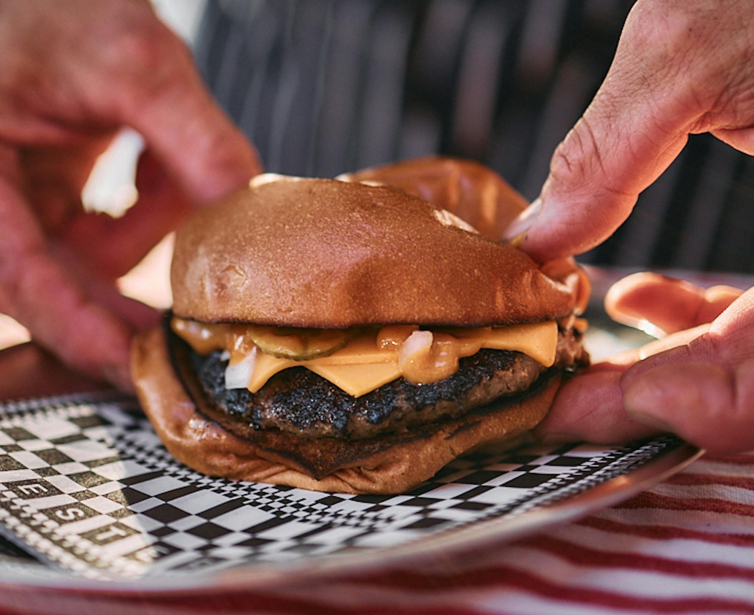 Hands holding a burger