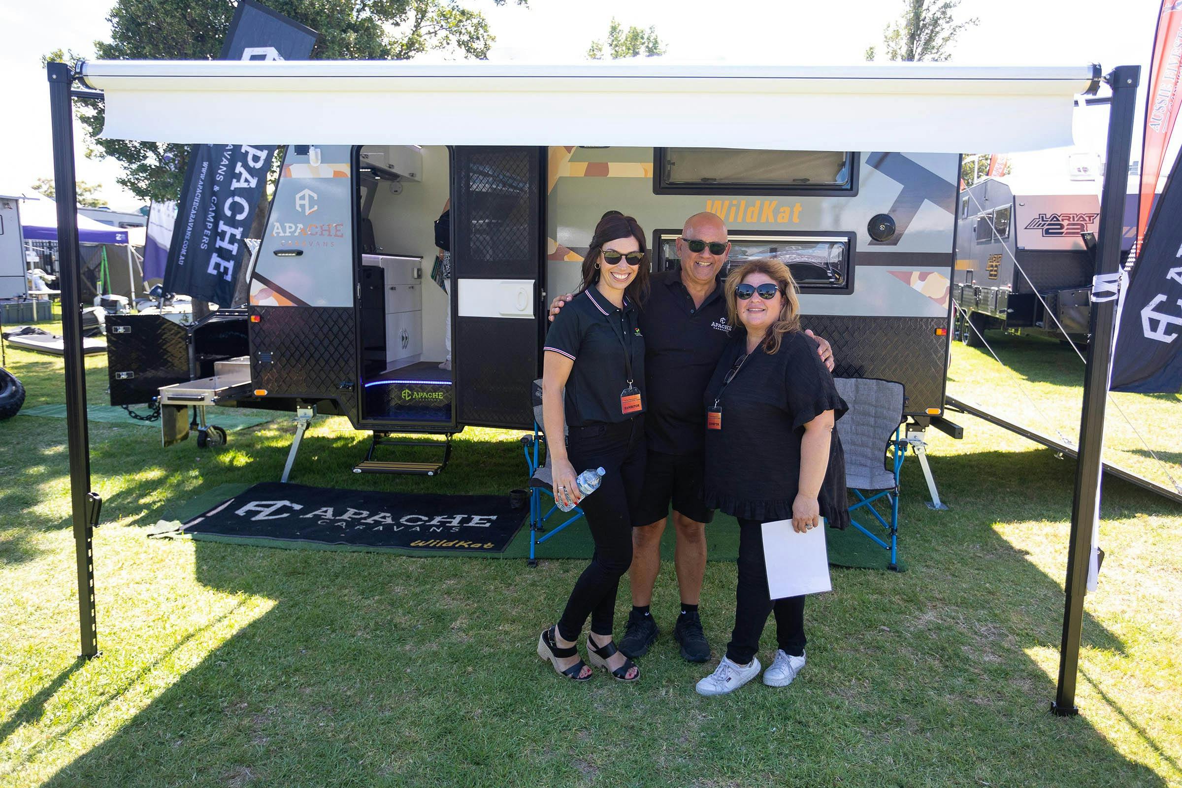 Friendly exhibitors under an awning of their caravan at the Outdoor Living & Caravan Expo