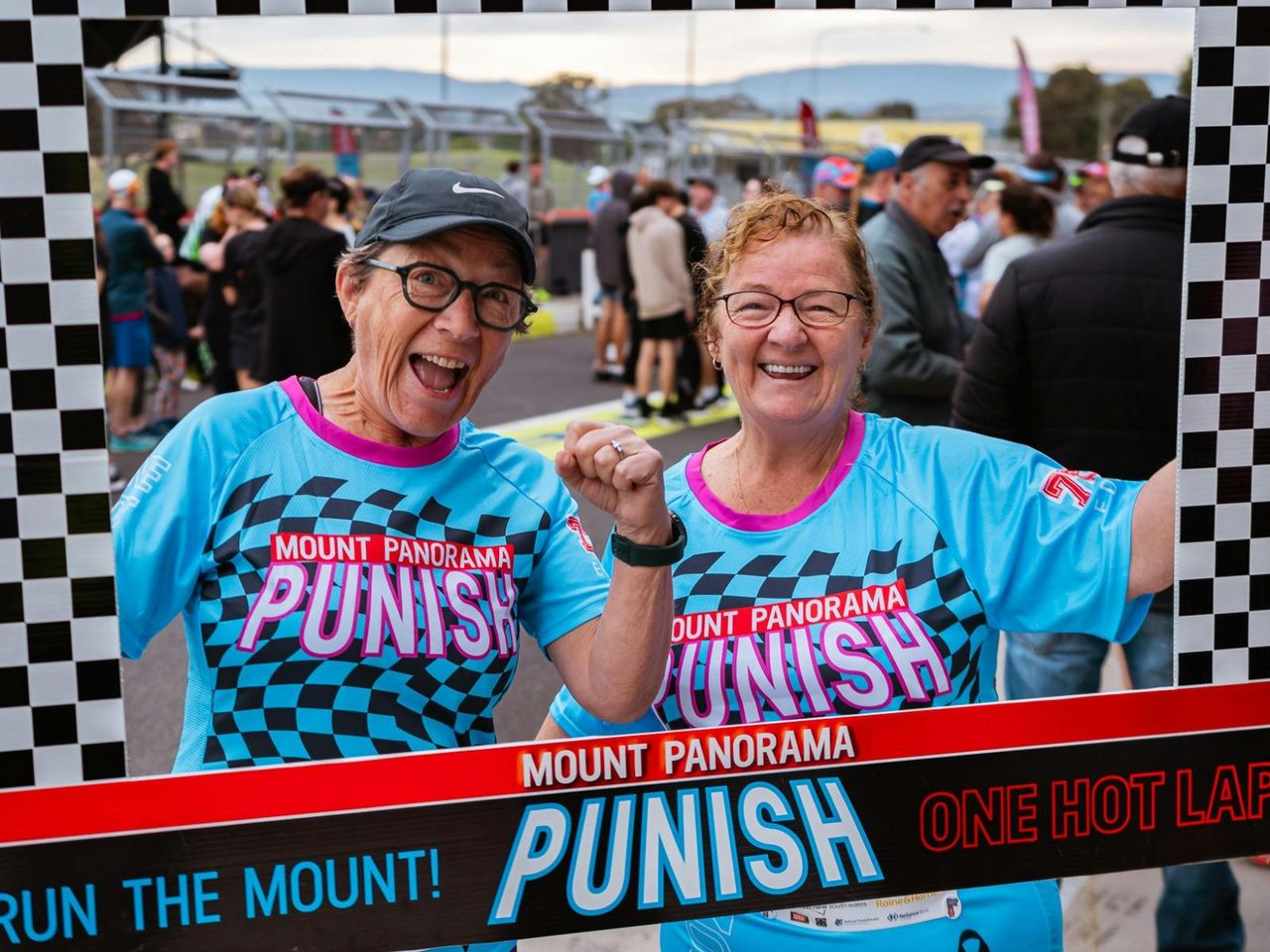 Two ladies posing in a Mount Panorama Punish photo op frame.