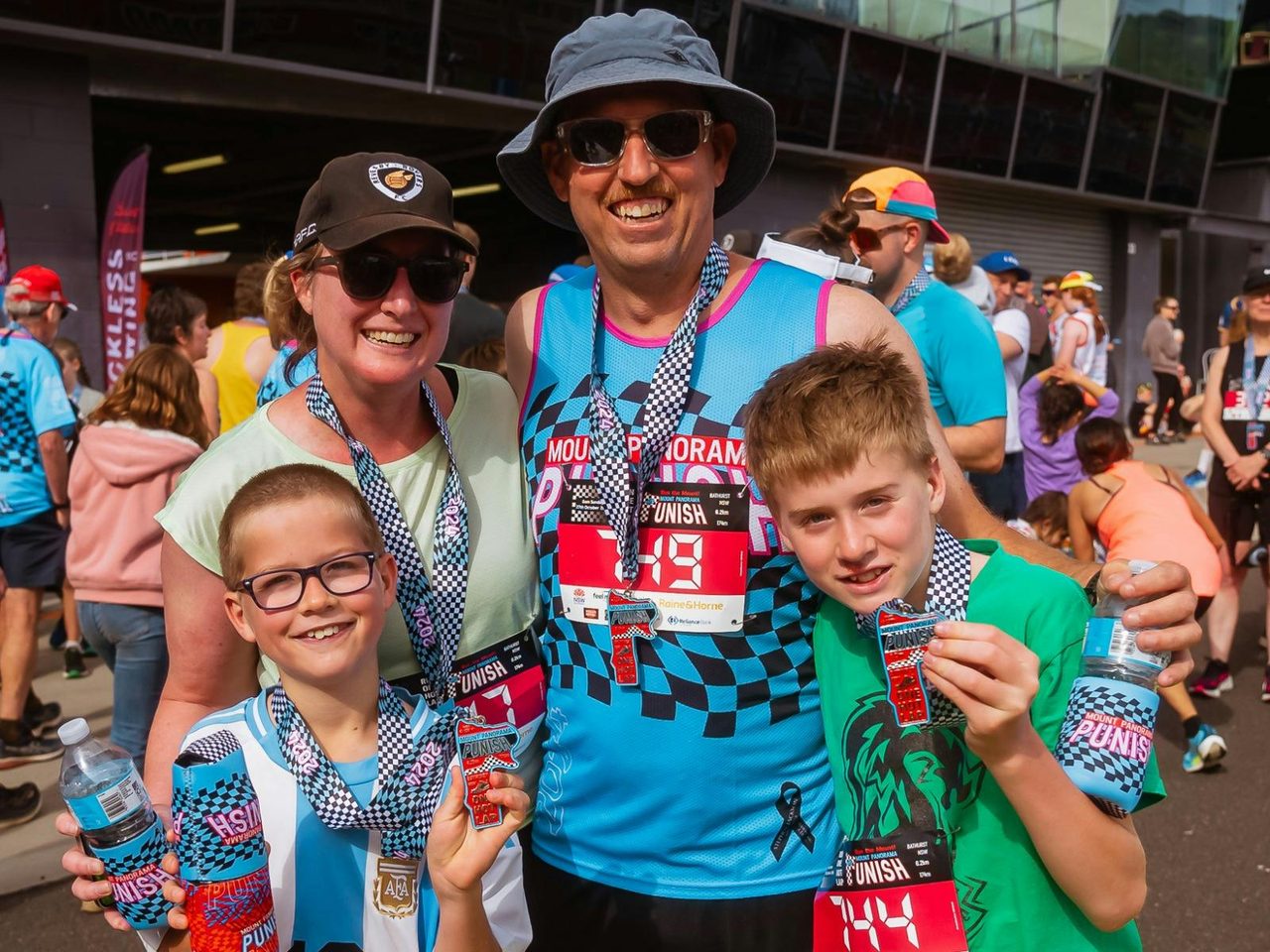 A family showing off their finisher medals at the Mount Panorama Punish.