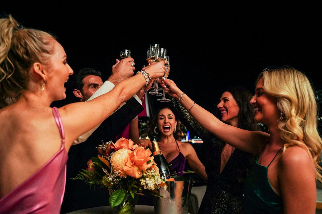 Group toasting with champagne on outside deck at night