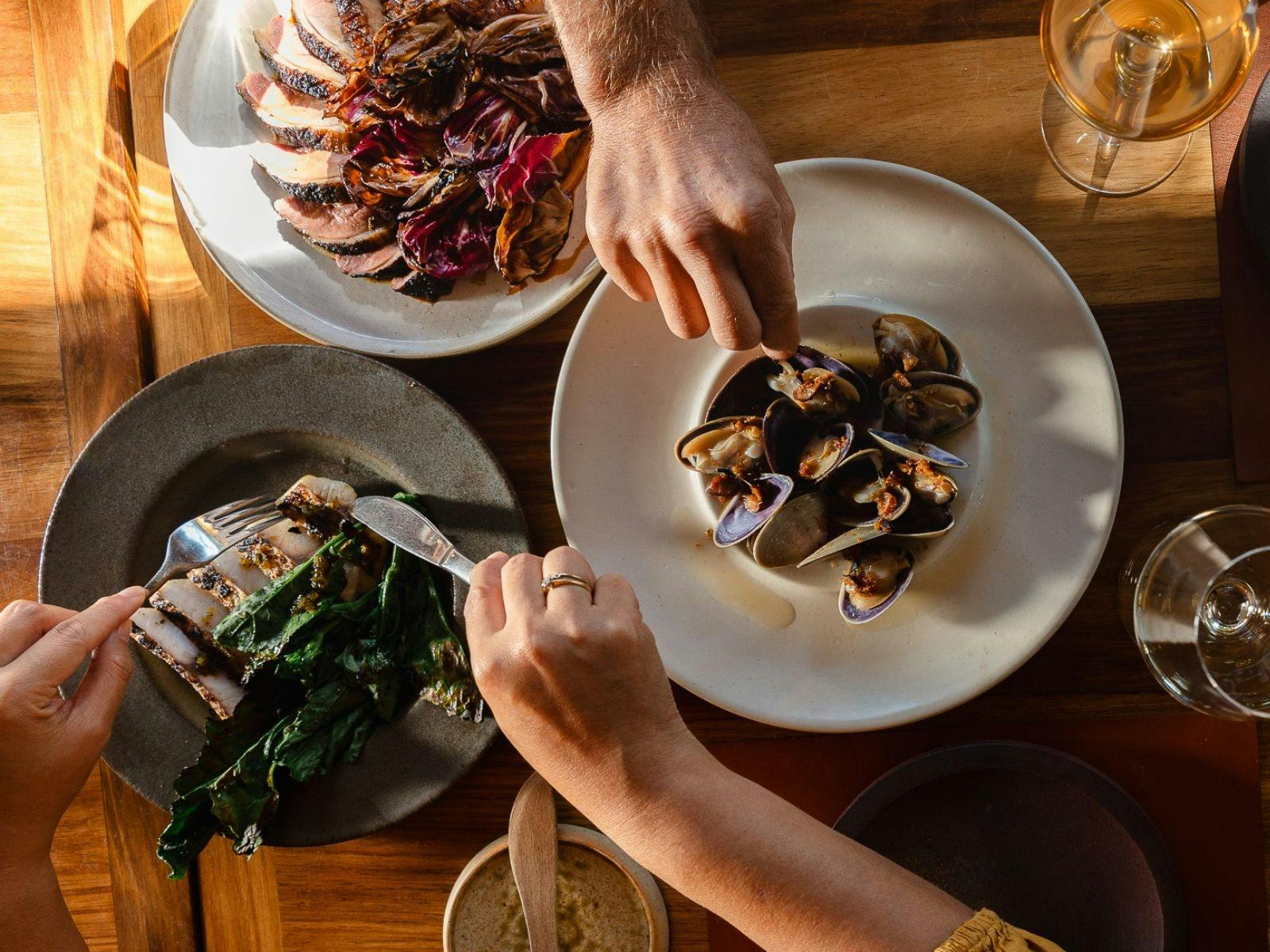 hands reaching in to plates of food