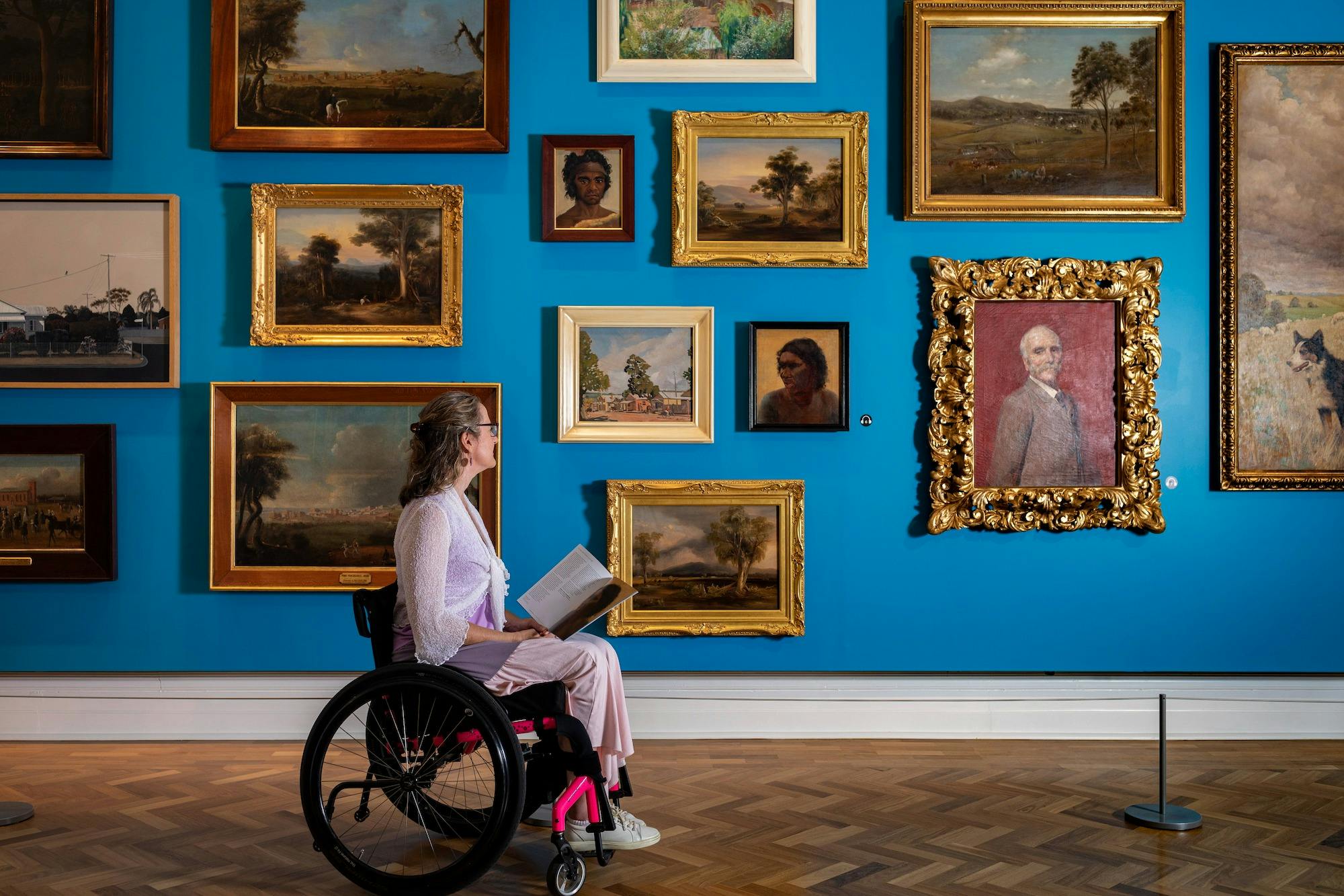 Person in wheelchair looking at art in a paintings gallery