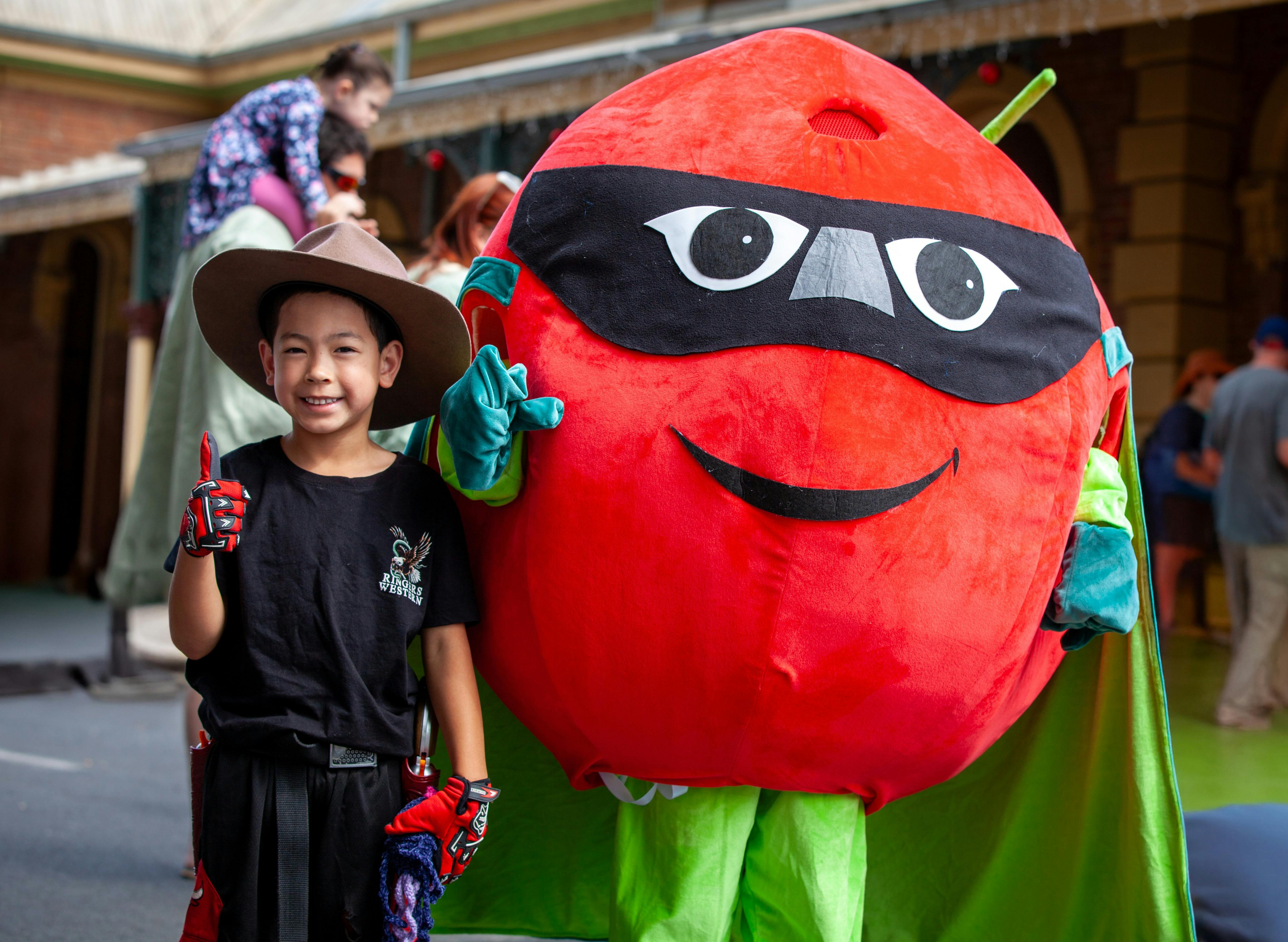 Cherry mascot posing with child