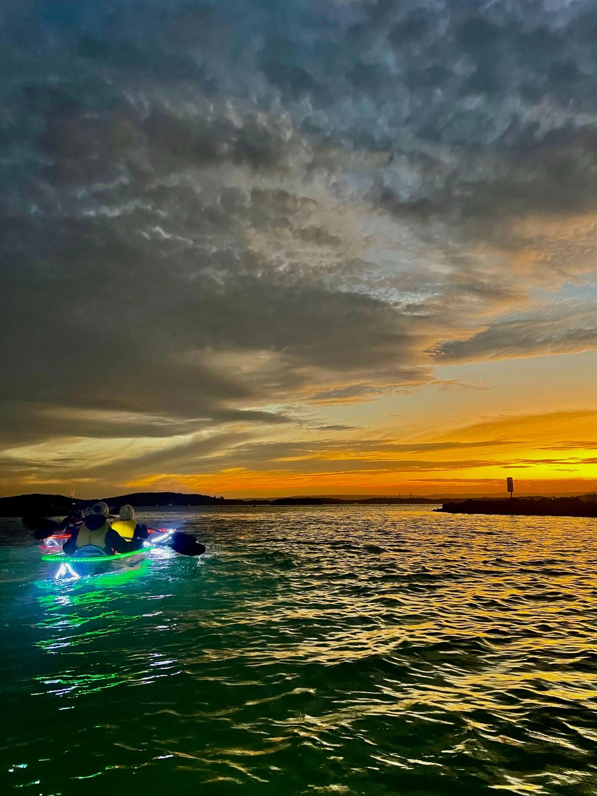 Clear kayak with lights at sunset.