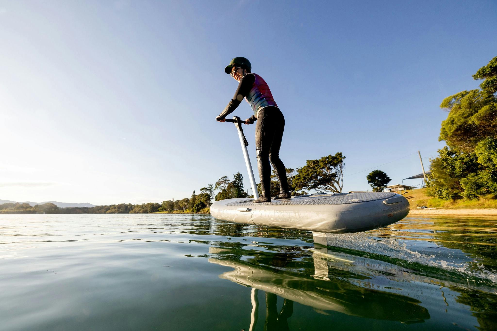 Rebecca riding the flitescooter hydrofoil, foiling above the river surface