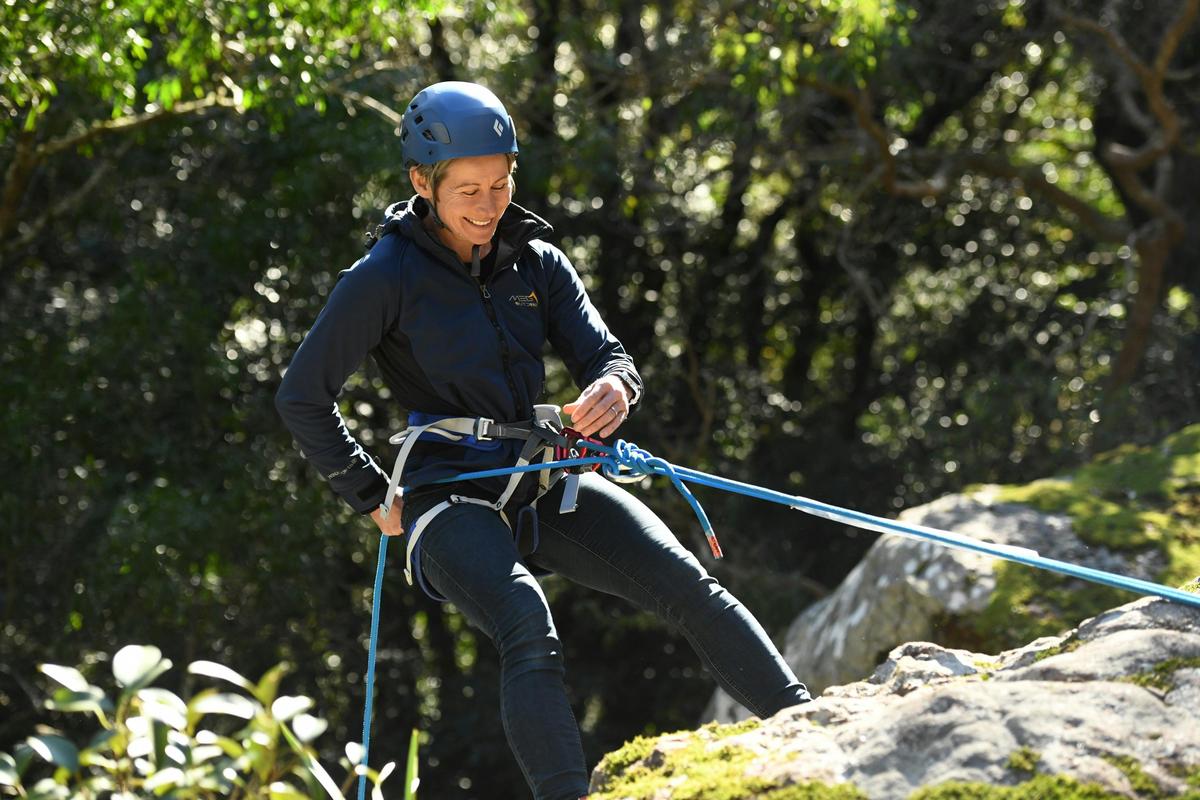 Smiling woman abseiling