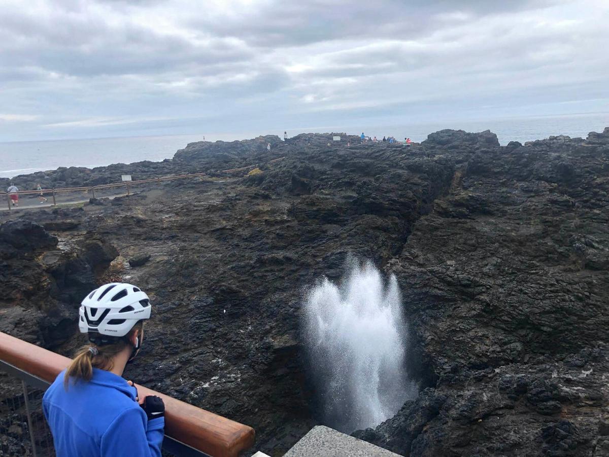 Cyclist viewing the Kiama Blowhole on the south coast cycle.