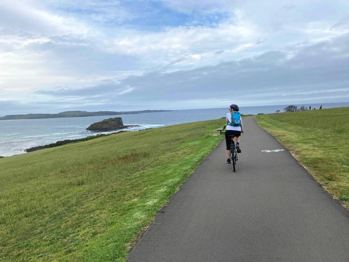 Cyclist viewing the Kiama Blowhole on the south coast cycle.
