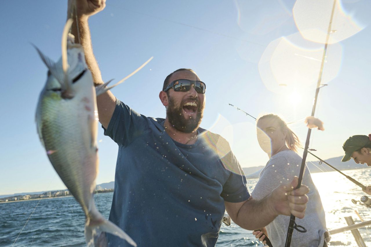 Man raising his catch in the air