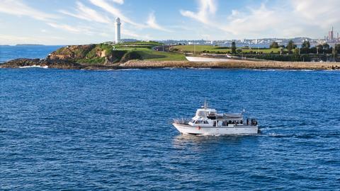 Vessel leaving Wollongong harbour with the lighthouse in the background