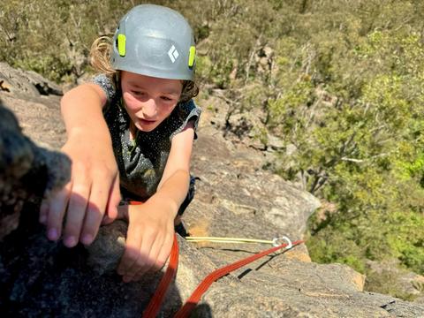 A young climber reaches for the next hold at Mount Boyce