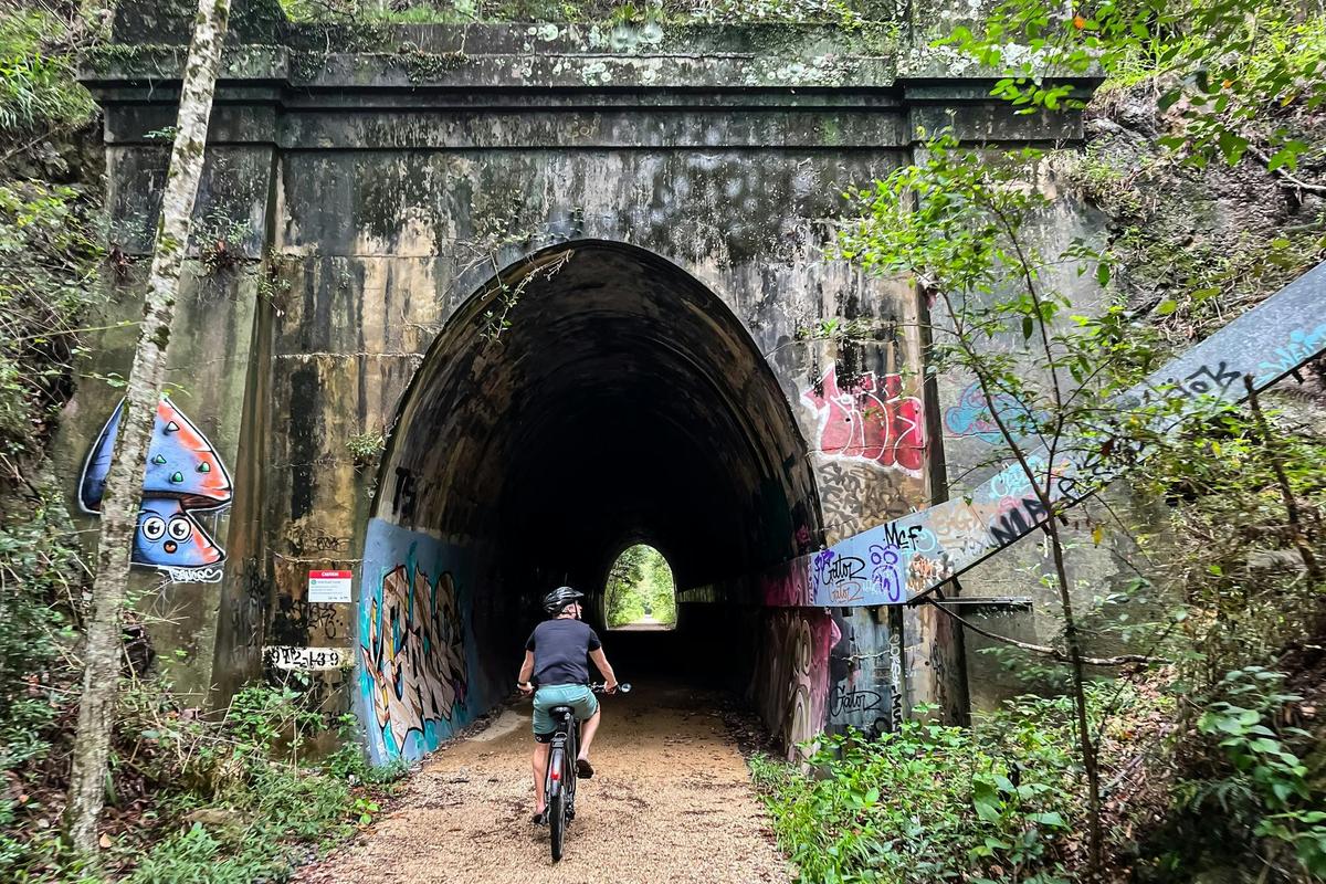 Rider on E Bike entering Hulls rd tunnel on the Northern Rivers Rail Trail self guided e bike tour