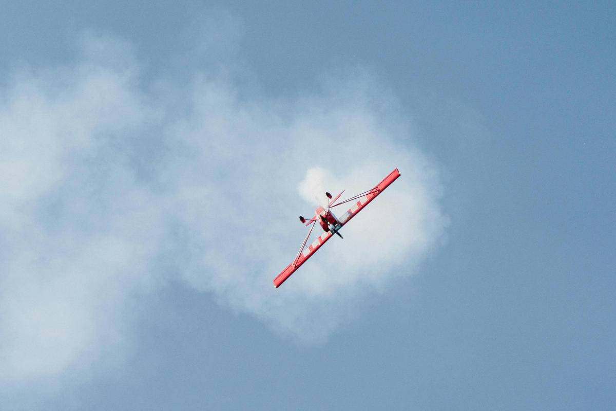 Pilot demonstrating an aerobatic move with smoke
