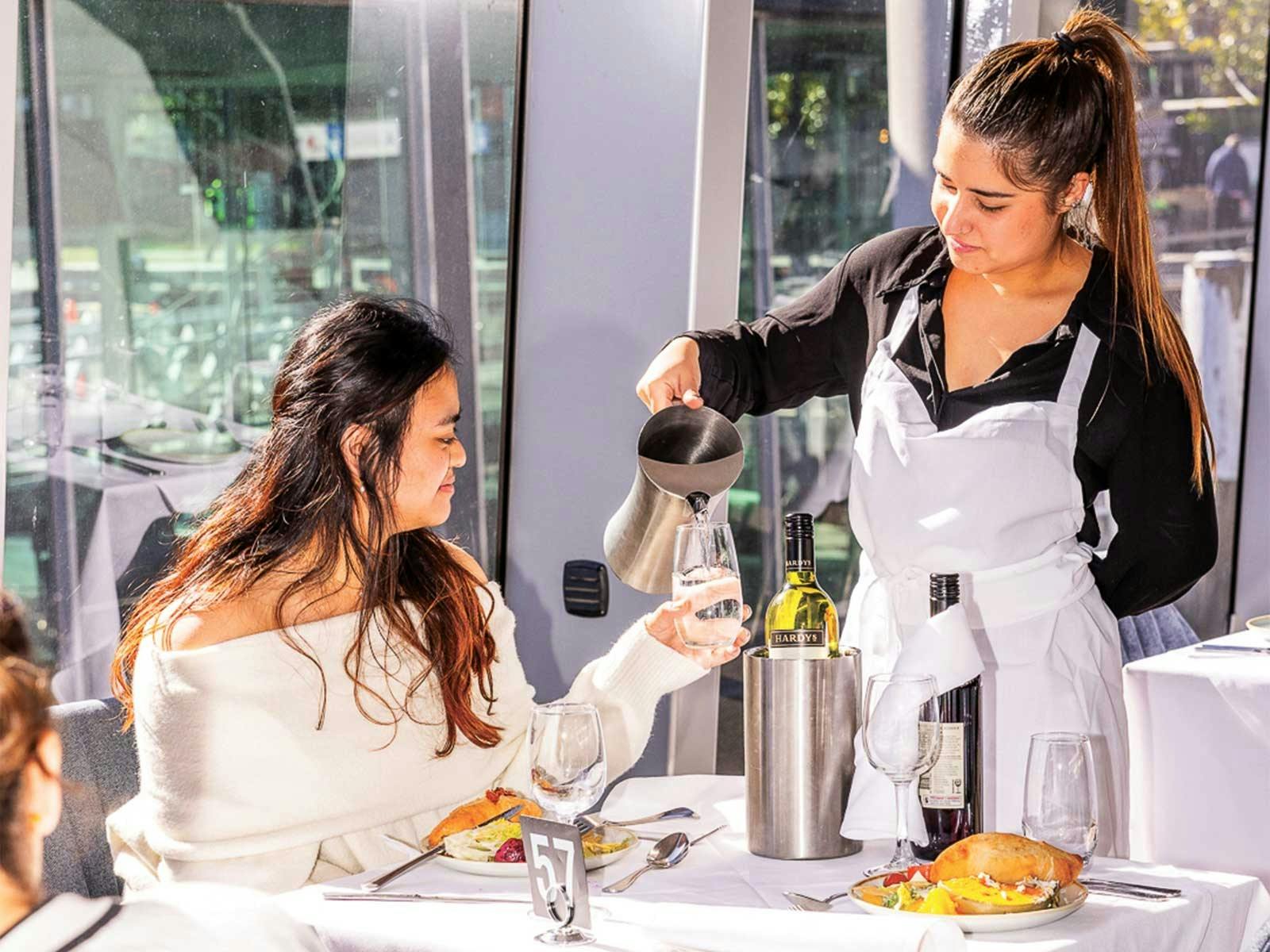 Waiter filling the drink for the guest on Clearview Glassboat