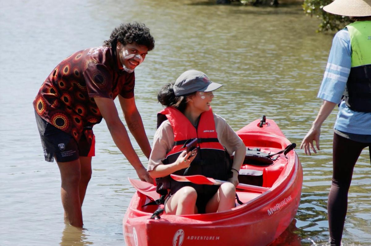 photo of a lady in canoe with worker assisting her