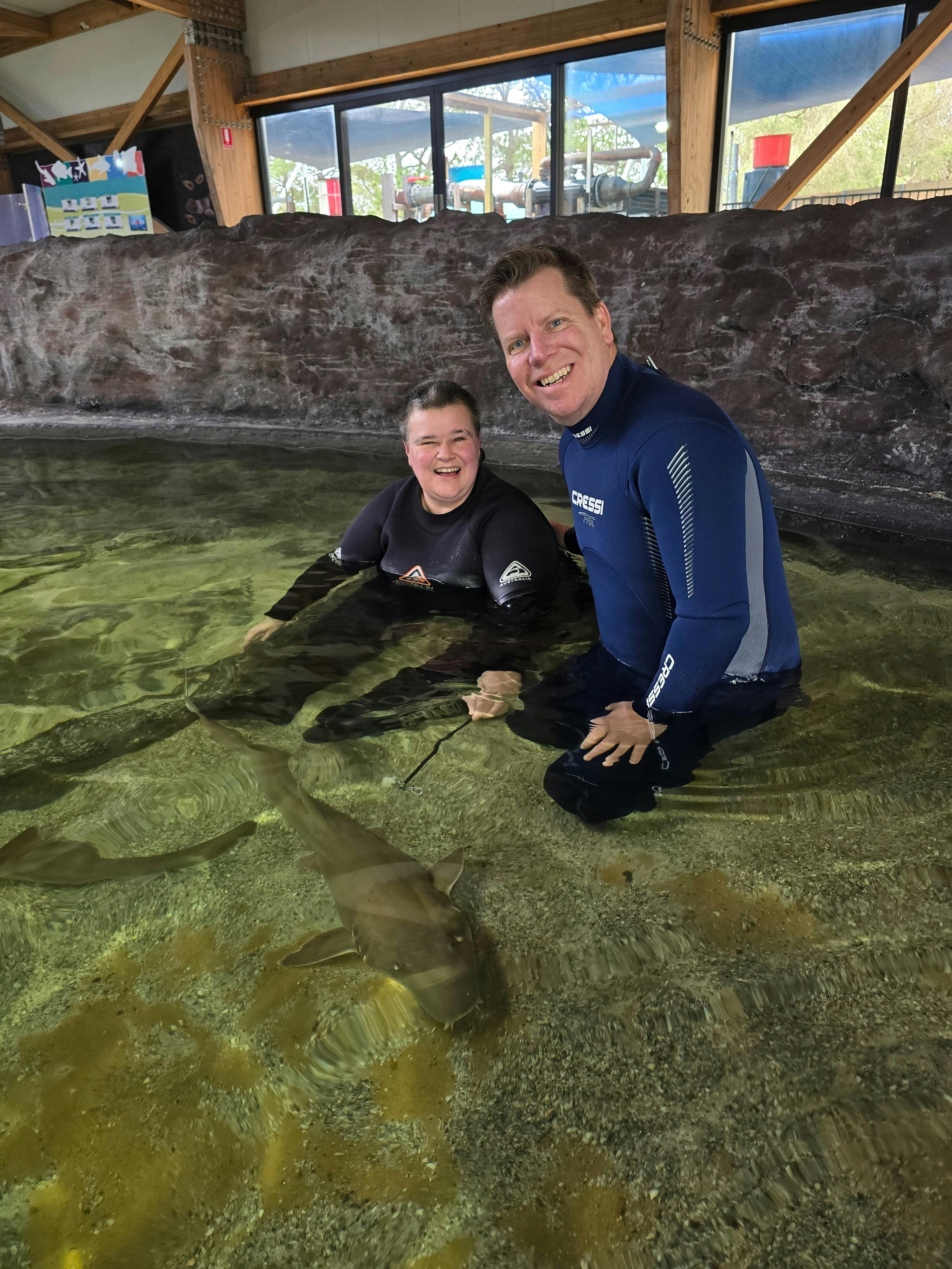 Traveller and tour leader petting a Bamboo Shark at Irukandji Shark & Ray Encounters