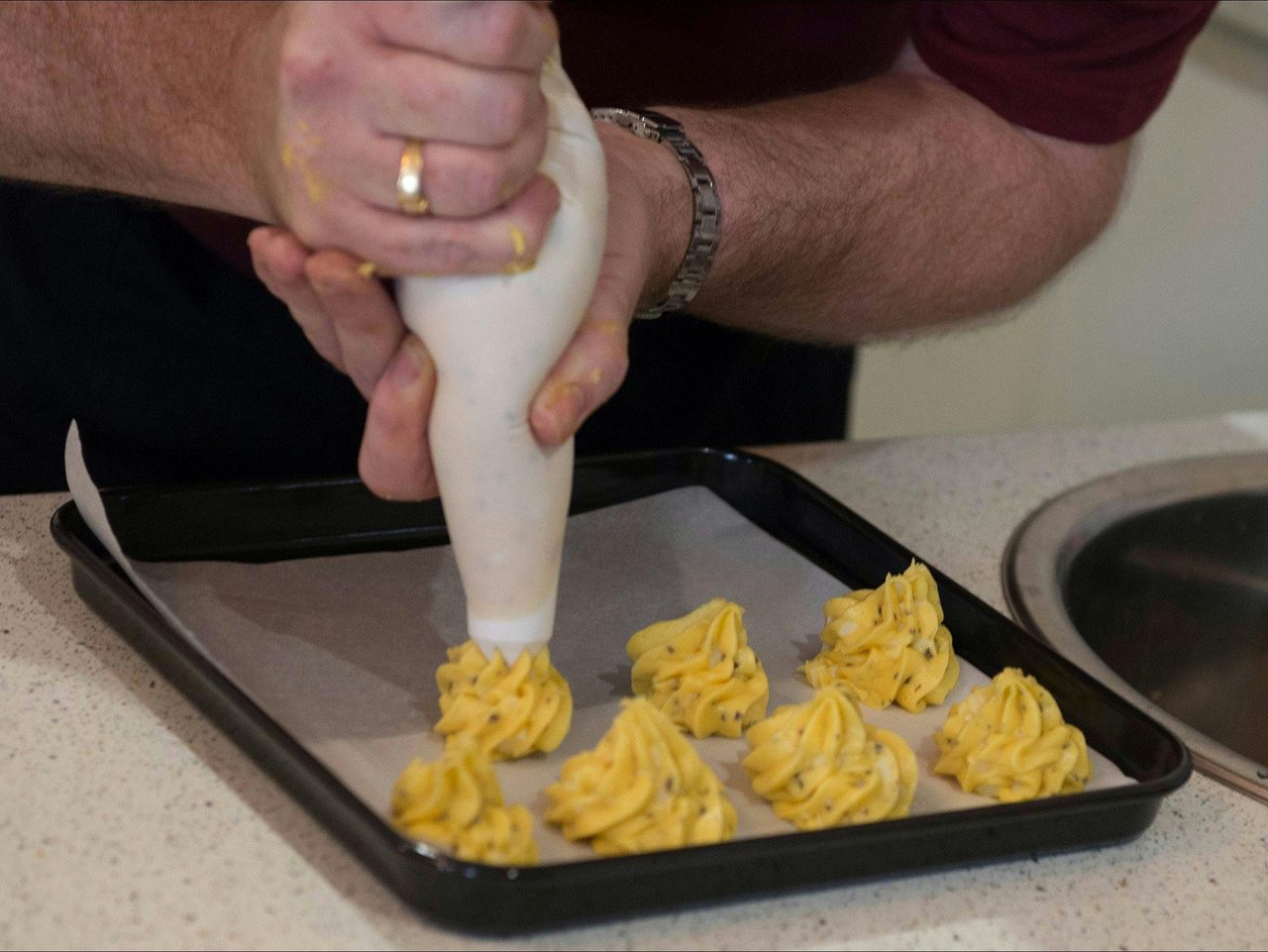 Chef John piping black truffle gougeres