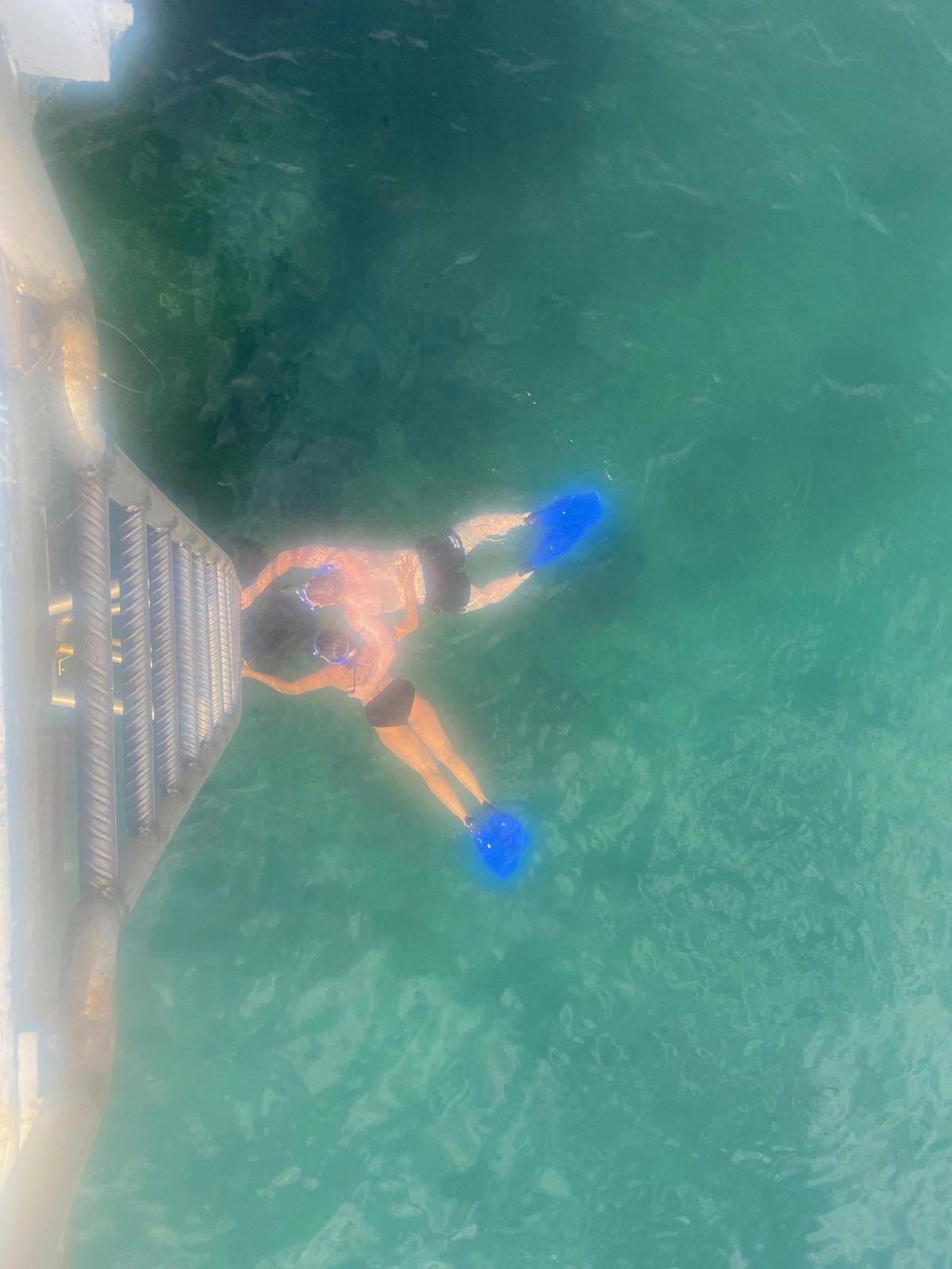 Aerial view of two people snorkeling in clear blue water