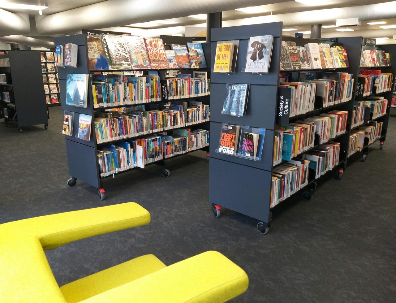Library travel section with green chair