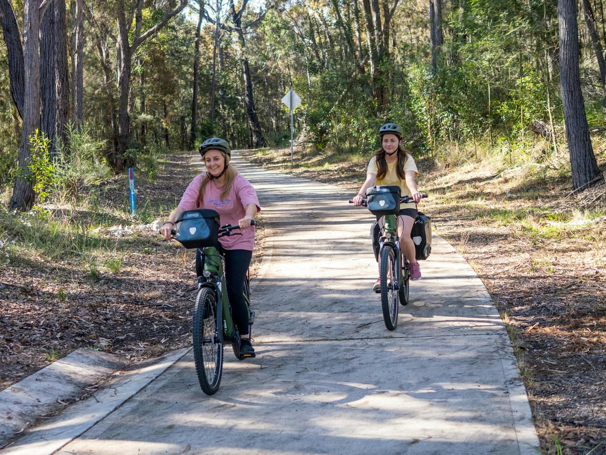 Two guests cycling ebikes between Tathra and Kalaru