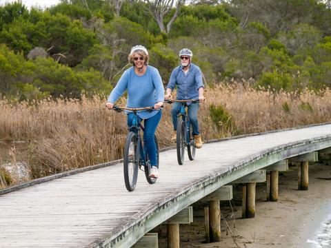 Guests cycling along the board walk at the lake