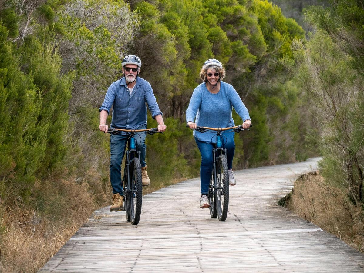 Guests cycling along the lake boardwalk